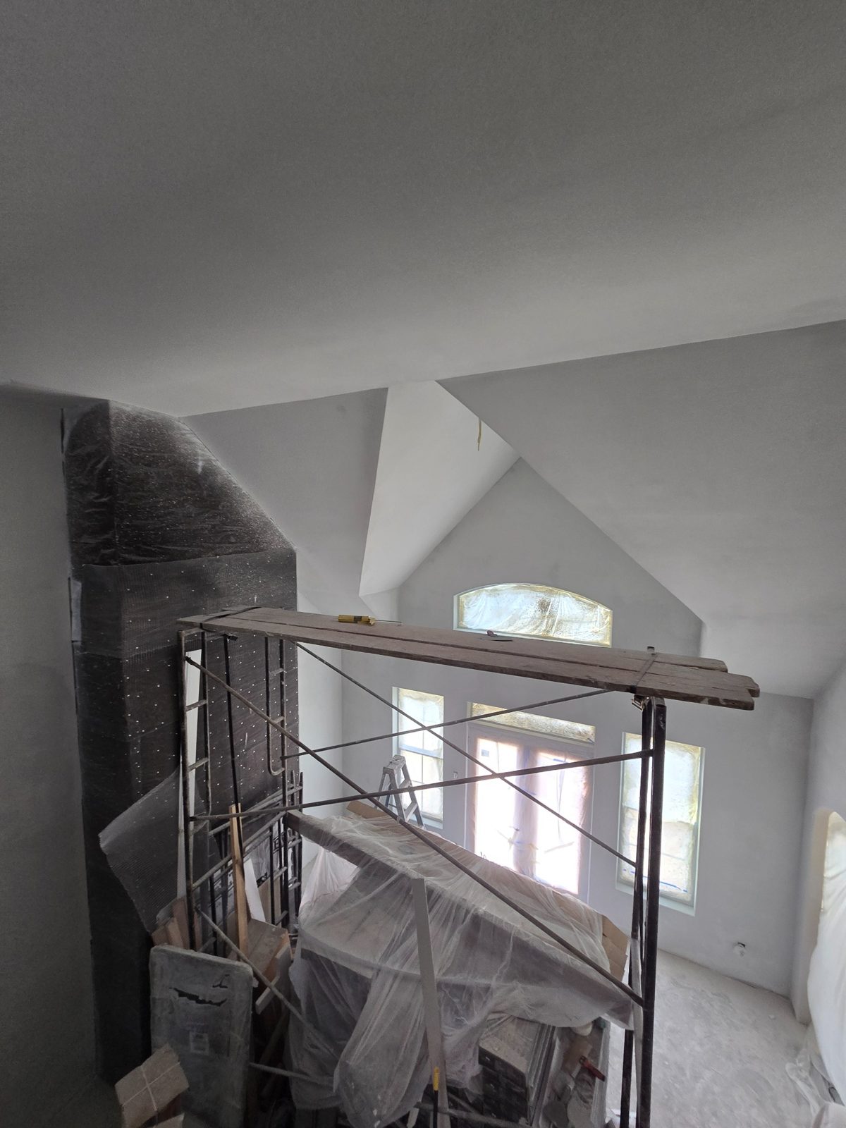 High ceiling drywall finishing on scaffold in a Fort Worth TX home